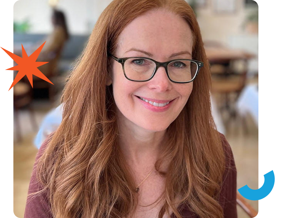 A woman with long red hair and glasses smiles in a blurred background setting. A starburst graphic is on the left side, and a blue curved shape is on the right.